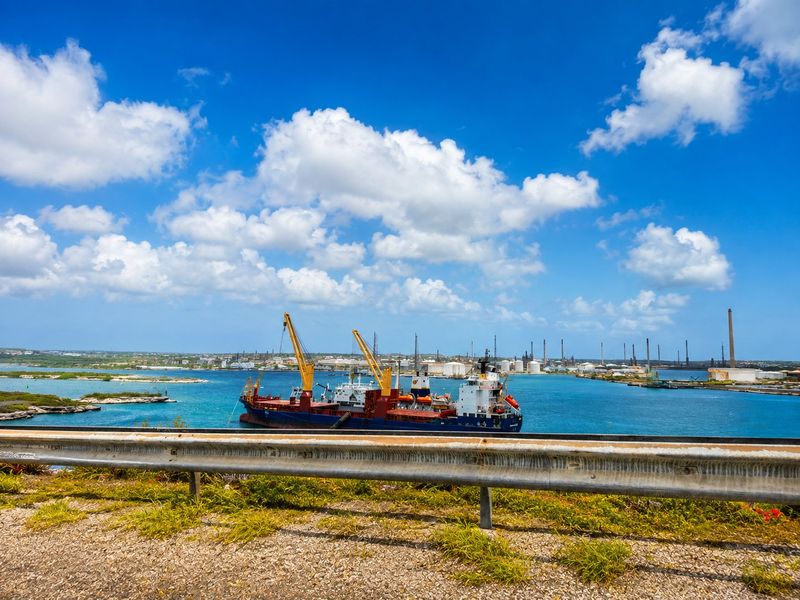 A cargo vessel alongside at Schottegat harbour in Curacao, with the refinery behind.